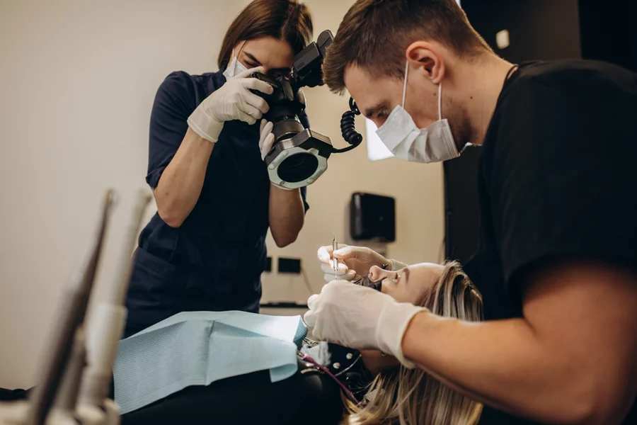 Dental technician using specialized equipment; part of the photogrammetry process with dental implants.